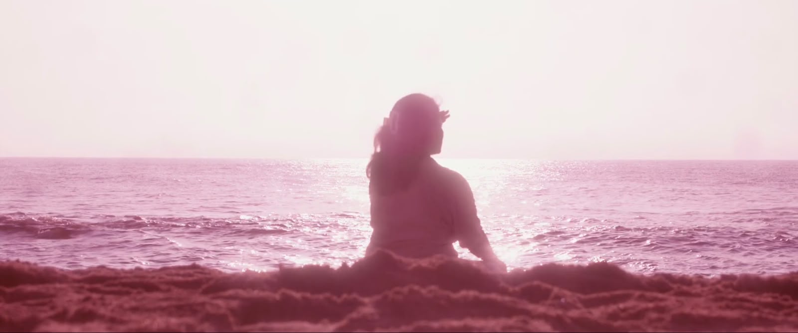 Figure seated by the sea